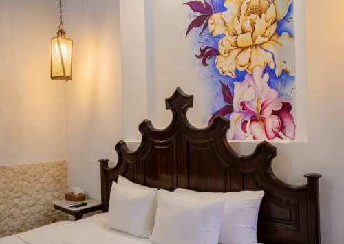 Dormitorio elegante en Villa Merida Boutique Hotel con cabecero oscuro ornamentado, almohadas blancas, linterna colgante y colorida