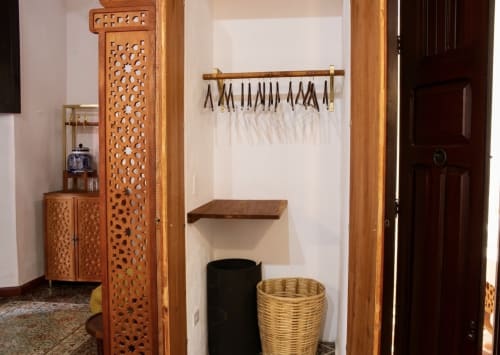 Rincón acogedor de la habitación del hotel boutique Villa Merida con estanterías de madera, almacenamiento decorativo y canasta tejida