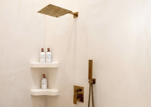 Área de ducha de lujo en Villa Merida Boutique Hotel con accesorios de latón, repisas flotantes y botellas de amenidades