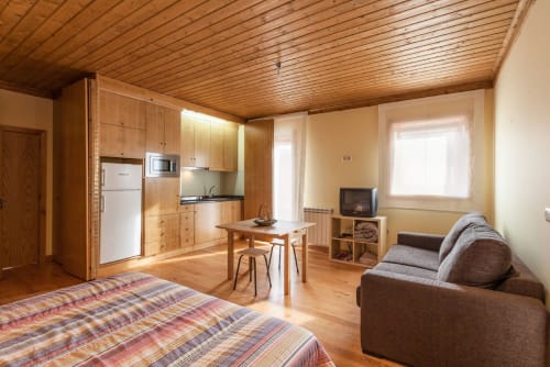 Estúdio em Casa da Lagiela em Fafe com cozinha de madeira, cama, sofá, mesa de jantar e vista para as montanhas