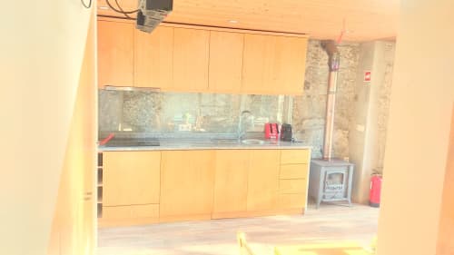Cozinha do apartamento rural Casa da Lagiela em Fafe com armários de madeira, bancada, pia e eletrodomésticos