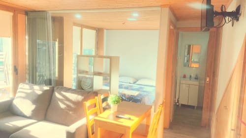 Área de estar clara na Casa da Lagiela com sofá, mesa de jantar e vista para quarto com acesso à piscina em Fafe