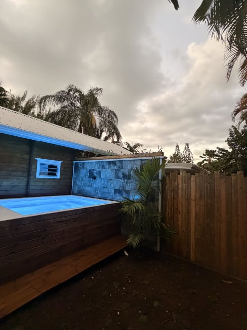Private pool at Filao Cottage in Sainte-Rose, Guadeloupe. Blue-lined cottage pool with wooden deck and tropical palm trees.