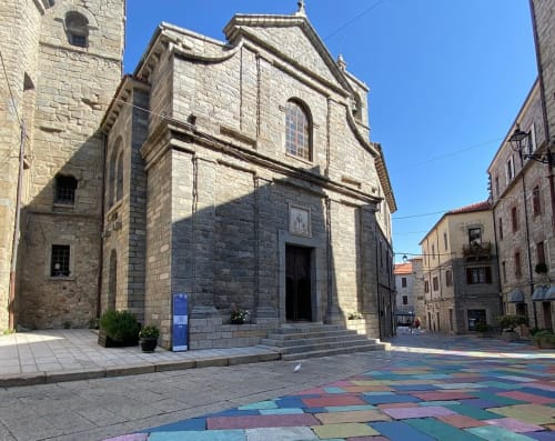 Chiesa in pietra storica con piazza piastrellata colorata a Valledoria, Italia vicino a A Mare Case Vacanze