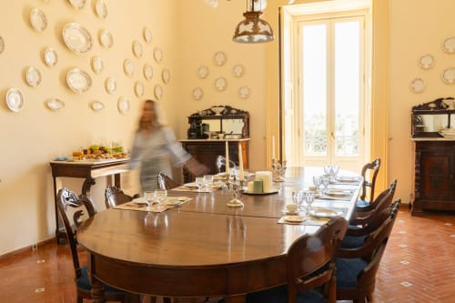Elegante sala da pranzo di Villa Ceci ad Andria con piatti decorativi e tavolo in legno
