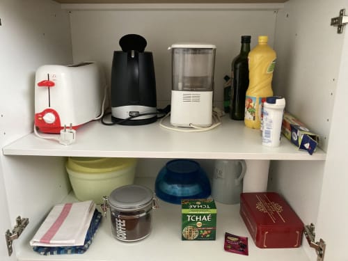 Étagère de placard de cuisine avec appareils et fournitures à l'appartement Chez Mimi, gîte de Châtillon-sur-Seine