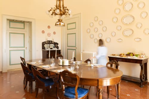 Elegante sala da pranzo di Villa Ceci B&B ad Andria con tavolo in legno, piatti decorativi, lampadario e porte d'epoca