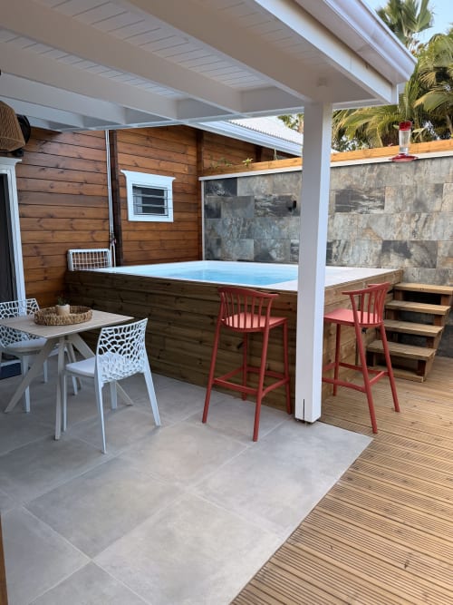 Filao Cottage's Anse des Îles private outdoor patio with hot tub, dining area, and stone wall in Sainte-Rose, Guadeloupe