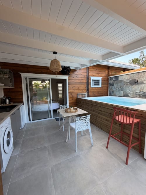 Modern cottage patio at Filao with pool, dining area, kitchen, and bedroom access in Sainte-Rose, Guadeloupe