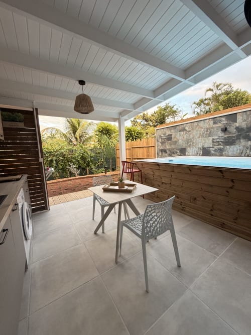 Anse Caraïbe cottage patio at Filao Cottage in Sainte-Rose with dining area, pool, and tropical garden view