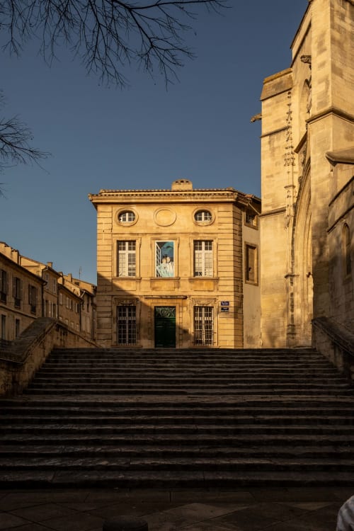 Golden stone facade of Le Prieuré Notre-Dame boutique hotel in Montfrin, France with classical architecture