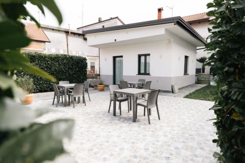 Modern patio at L'Amaranto B&B in Agerola with outdoor dining tables and chairs surrounded by greenery