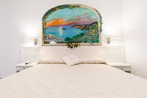 Bright bedroom at L'Amaranto B&B in Agerola with coastal sunset mural above bed