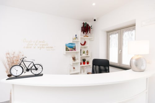L'Amaranto reception desk in Agerola with modern white desk, bicycle decor, and coastal shelving