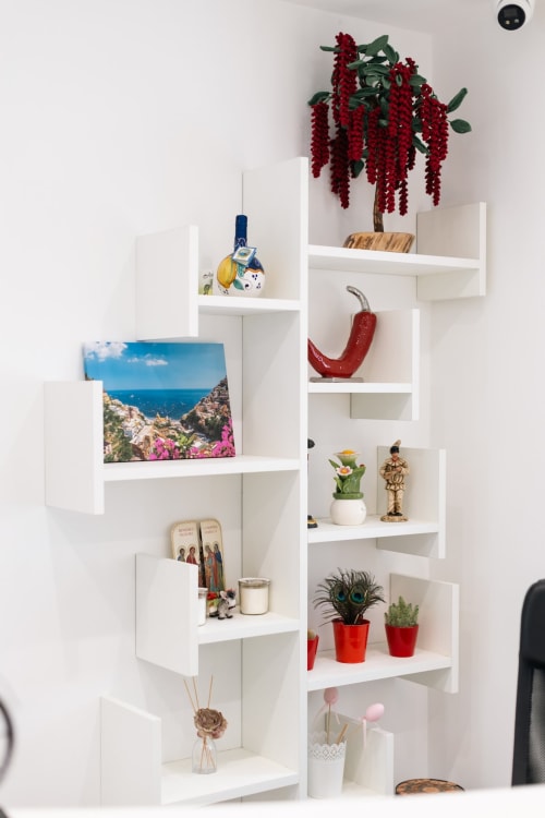 White wall shelves displaying home décor and plants at L'Amaranto BnB in Agerola, Italy