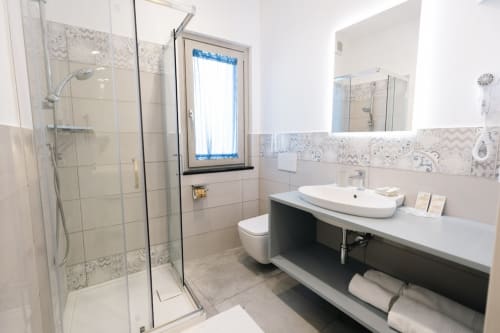 Modern bathroom at L'Amaranto BnB in Agerola with walk-in shower, vessel sink, and heated towel rack
