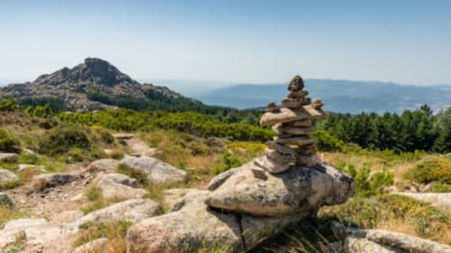 Suggestivo paesaggio montano con rocce impilate, picchi boscosi e vista lago presso Valledoria, Italia