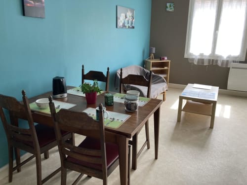 Salle à manger lumineuse du Chez Mimi à Châtillon-sur-Seine avec table en bois, chaises et vue sur la ville
