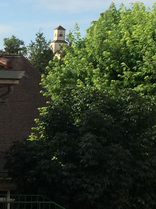 Le clocher de l'église se dresse au-dessus des arbres verdoyants de Chez Mimi à Châtillon-sur-Seine, France