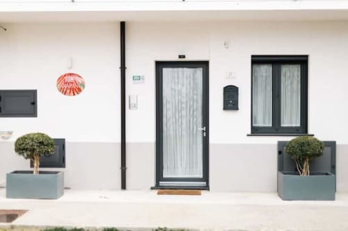 Ingresso di L'Amaranto BnB ad Agerola, Italia con porta nera moderna, piante in vaso e design minimalista
