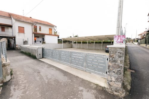 Ingresso dell'Amaranto BnB con cancello in metallo grigio e edificio bianco ad Agerola, Napoli
