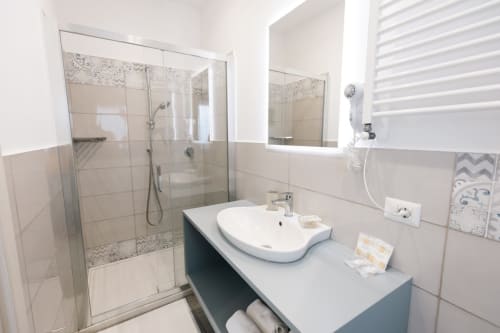Bagno moderno nella camera Sentiero delle Fonti di L'Amaranto B&B, Agerola con doccia walk-in, lavabo curvo e scaldasalviette