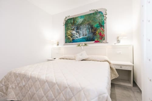 Bright bedroom at L'Amaranto B&B in Agerola with white bed, built-in headboard, and waterfall artwork above TV