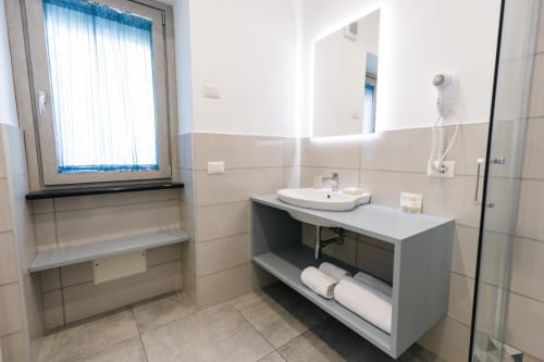 Modern bathroom at L'Amaranto B&B in Agerola with sink, mirror, window, and towel storage