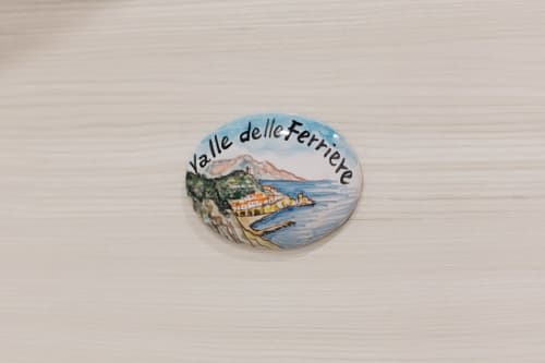 Ceramic souvenir plate depicting Valle delle Ferriere coastal landscape with mountains and traditional architecture, Agerola
