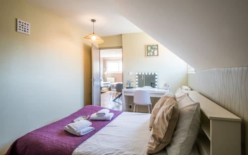 Bright apartment bedroom in Millau with purple runner, desk with mirror, city views, and modern amenities