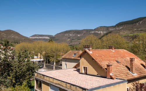 Bright apartment in Millau with city views overlooking hills, terracotta roofs, and green vegetation from rooftop