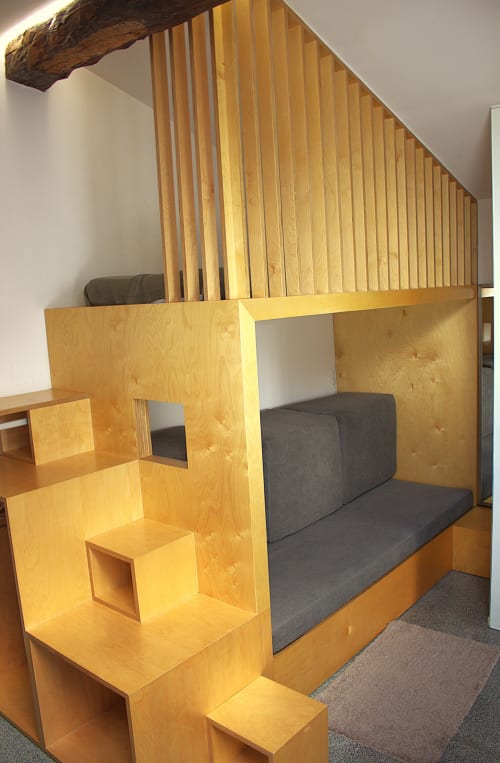 Wooden loft bed with gray mattress and built-in stairs in rural Portuguese apartment at Pera da Serra