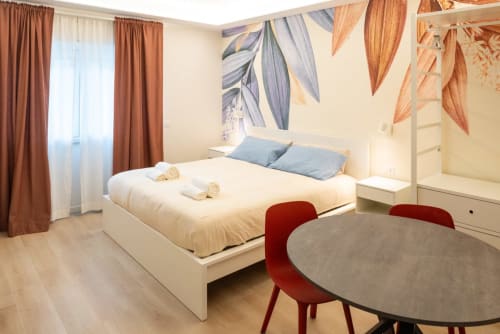 Suite Flavia Deluxe presso EQM Roma con letto matrimoniale, arredamento moderno, scrivania di lavoro e vista sulla città