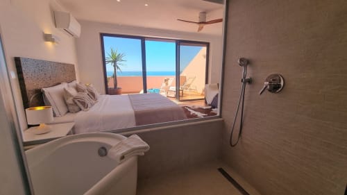 Luxuosa casa de banho com vista para o oceano em King's House Ericeira, com banheira, duche e quarto com vista para o mar