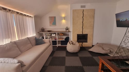 Sala de estar moderna no apartamento King's House Ericeira com sofá bege, lareira, vista para o mar e área de entretenimento