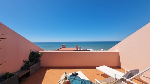 Terraço em terracota da King's House Ericeira com vista para o mar, litoral e praia