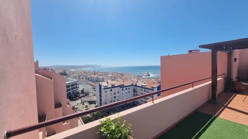 Terraço com vista para o mar na King's House Ericeira com a vila costeira e oceano ao fundo