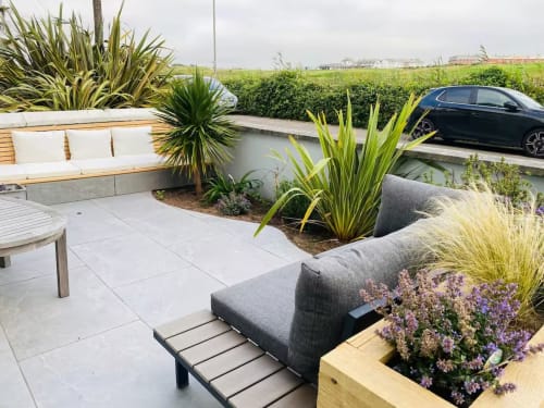 Modern terrace at 2 Doves Holiday Property, Exeter, with seating, tropical plants, and countryside views
