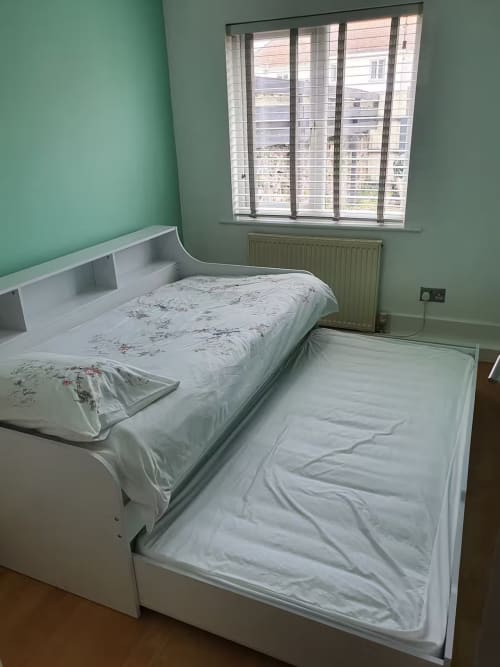 Twin beds with white bedding in a mint green bedroom at 2 Doves Holiday Property, Exeter, with large windows overlooking the