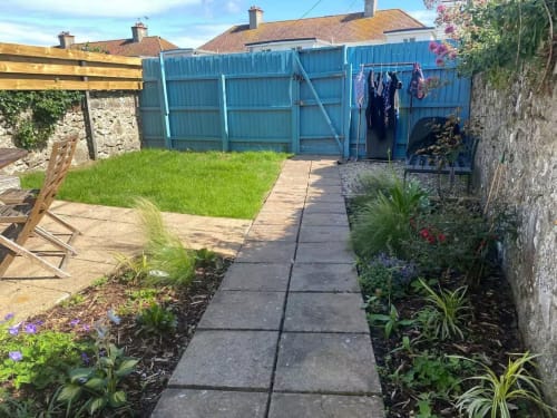 Blue shed and garden pathway at 2 Doves Holiday Property in Exeter with flowering borders and manicured lawn