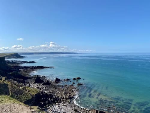 Dramatic coastal cliffs with turquoise waters near 2 Doves Holiday Property in Exeter