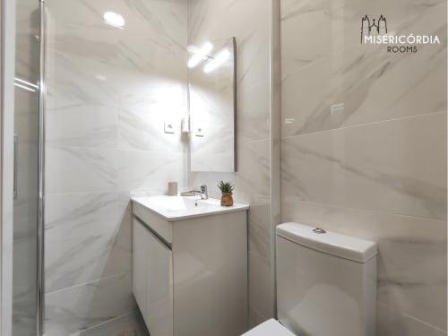 Banheiro moderno do quarto Portas Do Sol no hotel SM Stays Collection em Guarda, Portugal, com azulejos de mármore, lavatório e chuveiro