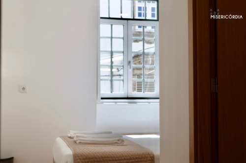 Quarto luminoso na SM Stays Collection em Guarda com vista pela janela, cama impecavelmente arrumada com toalhas