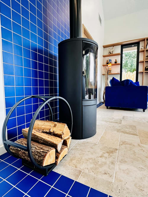 Cheminée contemporaine avec rangement à bois à L'Instant Cottage, Amboise. Mur en carrelage bleu, étagères bois et velours bleu