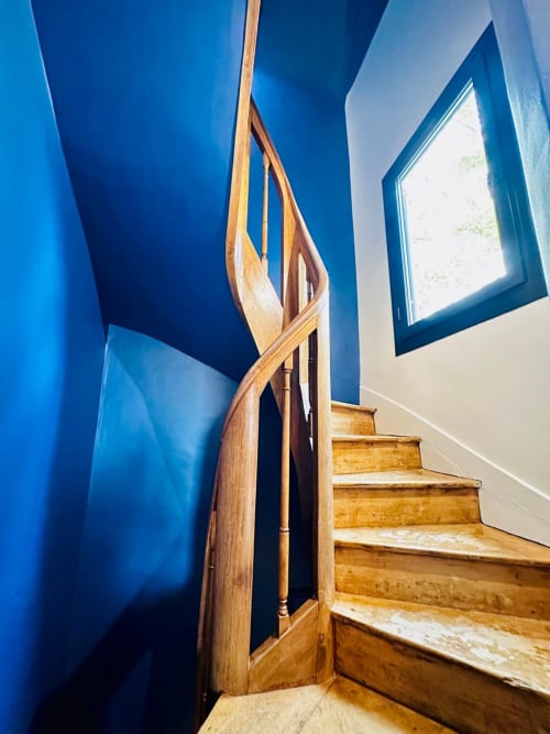 Escalier en bois, murs bleus et lumière naturelle de la maison L'Instant Clos Lucé à Amboise.