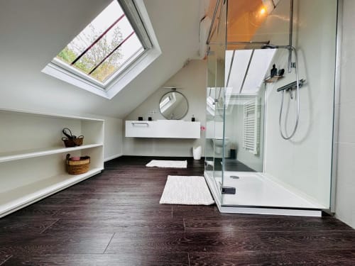 Salle de bain moderne avec puits de lumière, douche à l'italienne, lavabo blanc, parquet foncé et rangements intégrés à l'Instant Clos Lucé
