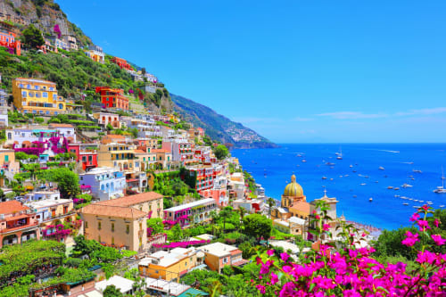 Affascinante villaggio di Positano arroccato sulla scogliera, con edifici vivaci, bouganvillea e il blu Mare Mediterraneo