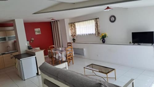 Studio ouvert Appart'Hôtel Cholet avec cuisine, salle à manger, séjour, mur d'accent rouge et mobilier moderne