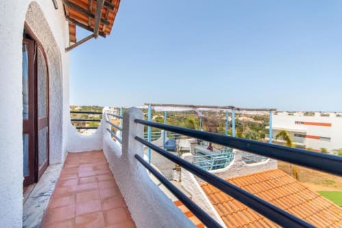 Terraço da varanda da Villa Principezinho BnB em Portugal com vista para o campo, telhados em terracota e grades azuis