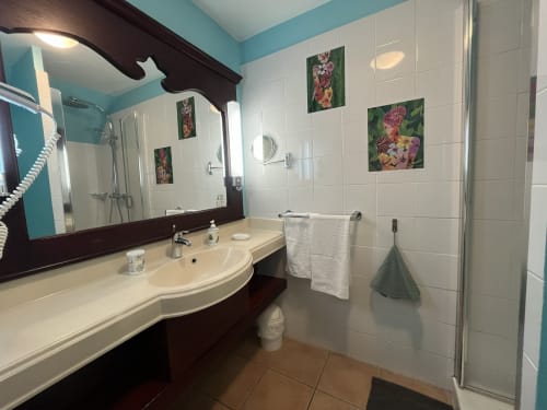 Salle de bain moderne de l'appartement PREMIUM Tobago à Tropic Appartements, Sainte-Anne, avec murs turquoise, carrelage blanc et